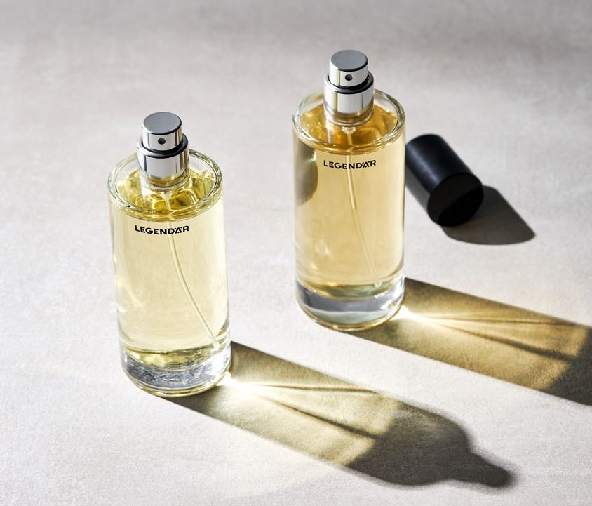 Legendär Eau de Parfum – Geöffnete Duftflakons mit Lichtspiel und Schattenwurf Zwei geöffnete Legendär Eau de Parfum Flakons mit Lichtreflexionen auf hellem Untergrund in Betonoptik